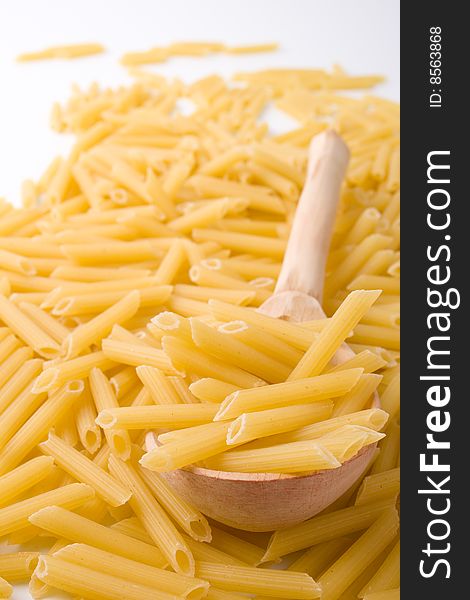 Raw italian macaroni and wooden spoon