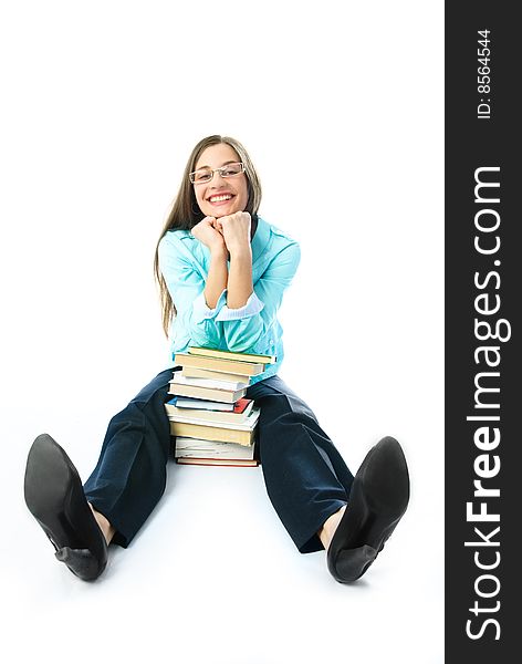 Young cheerful student sitting on the floor with a lot of books and smiling. Young cheerful student sitting on the floor with a lot of books and smiling