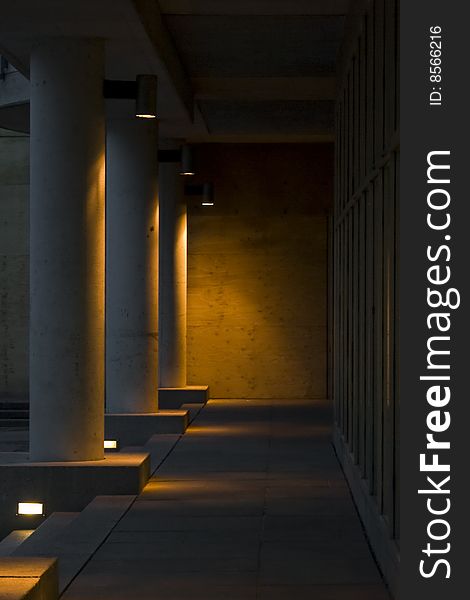 Concrete pillars under building illuminated with yellow tungsten lights in evening. Concrete pillars under building illuminated with yellow tungsten lights in evening.