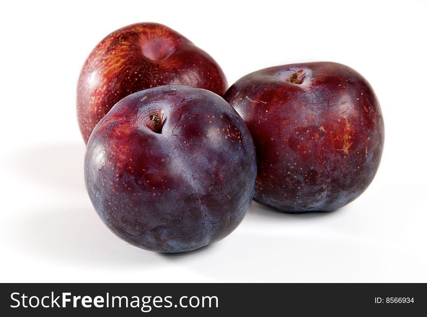 Three red plums on a white background. Three red plums on a white background.