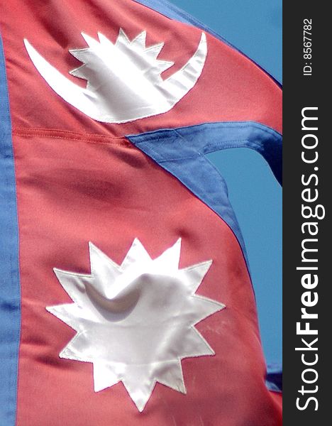The flag of Nepal against blue sky. The flag of Nepal against blue sky
