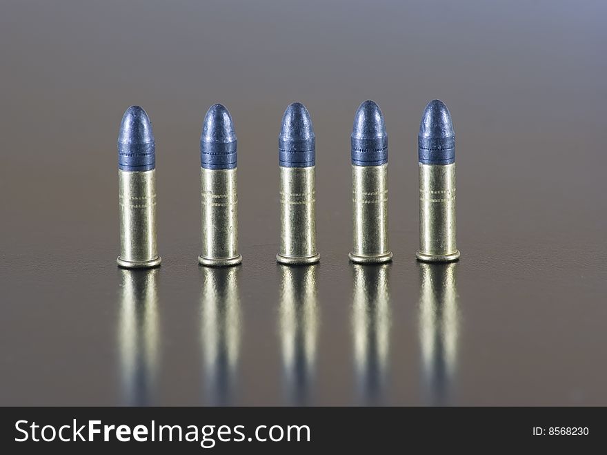 Five 22 long rifle rimfire cartridges on a table