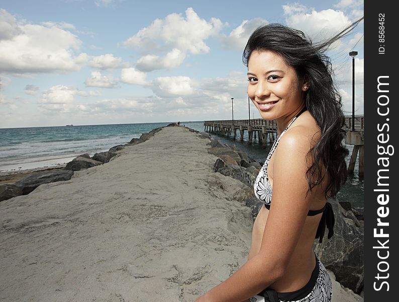 Beautiful young woman smiling in a beach scene. Beautiful young woman smiling in a beach scene