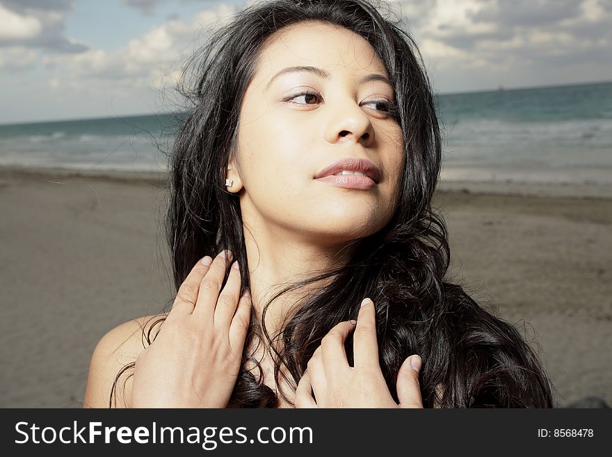 Young woman glancing away while touching her hair. Young woman glancing away while touching her hair