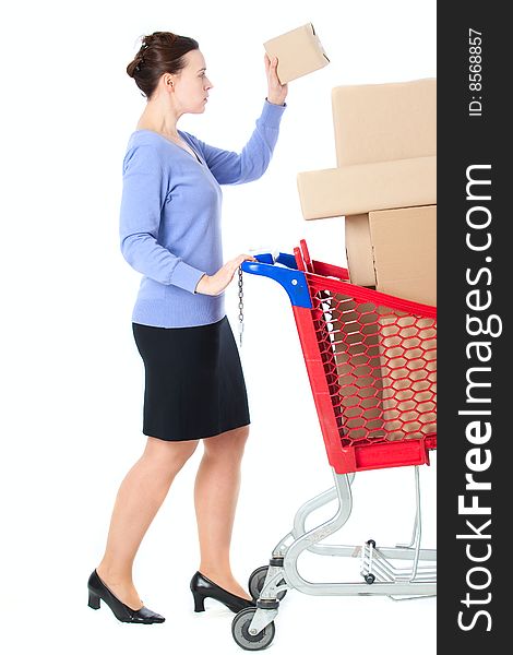 A woman with a shopping trolley full of goods on white. A woman with a shopping trolley full of goods on white