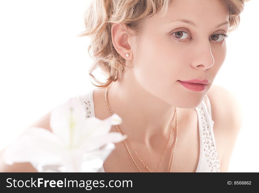 Portrait of attractive blond girl with white lily over white background