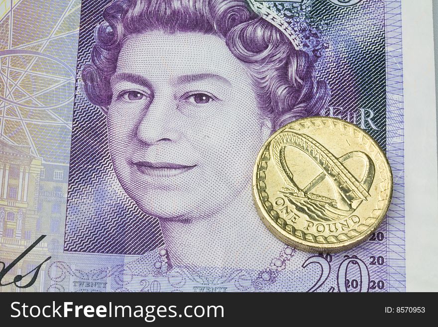 twenty pound note with a pound coin. twenty pound note with a pound coin