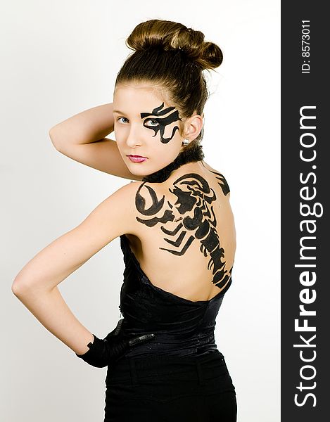 Girl with black scorpio sign painted on back and face. Girl with black scorpio sign painted on back and face