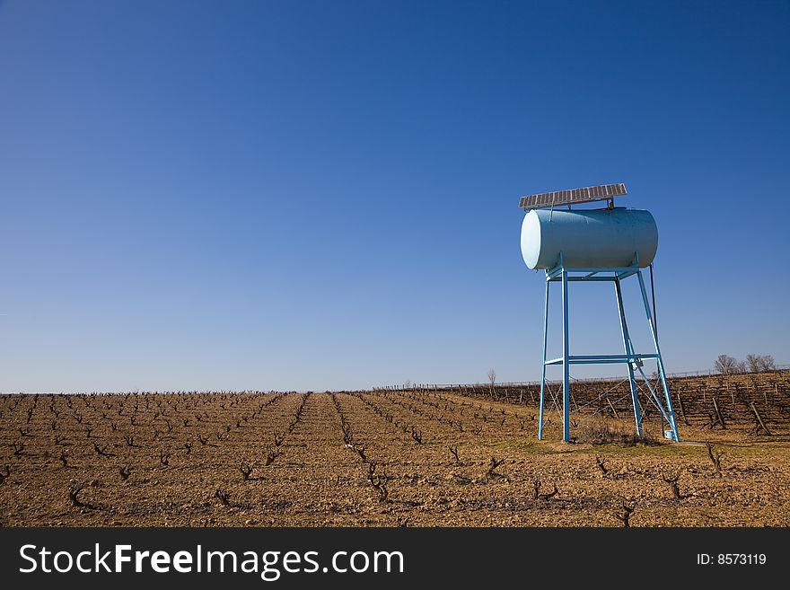 Water reservoir for irrigation with solar panels in a vineyard. Water reservoir for irrigation with solar panels in a vineyard