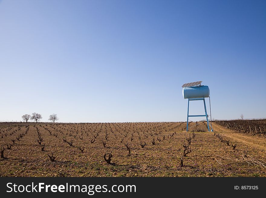 Water reservoir for irrigation with solar panels in a vineyard. Water reservoir for irrigation with solar panels in a vineyard