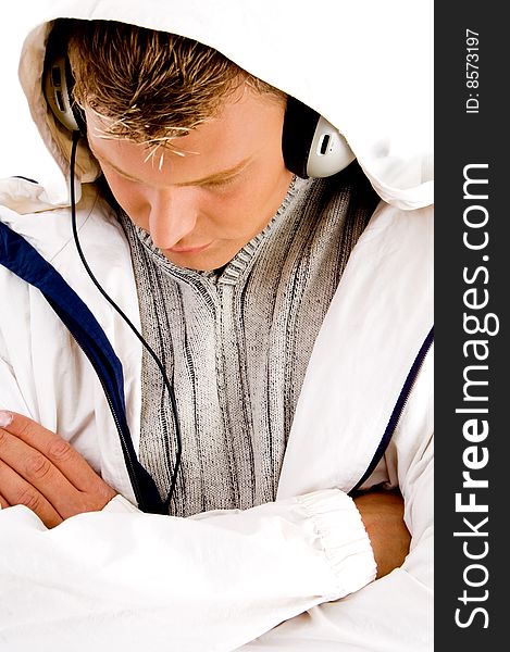 Young guy listening to music with headphones against white background