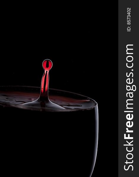 A Drop Of Red Wine Falls Into The Glass