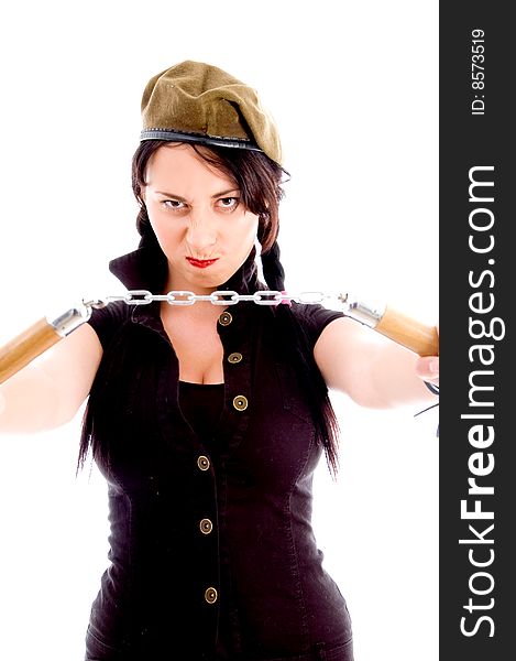 Young woman holding nunchaku in anger posing against white background. Young woman holding nunchaku in anger posing against white background