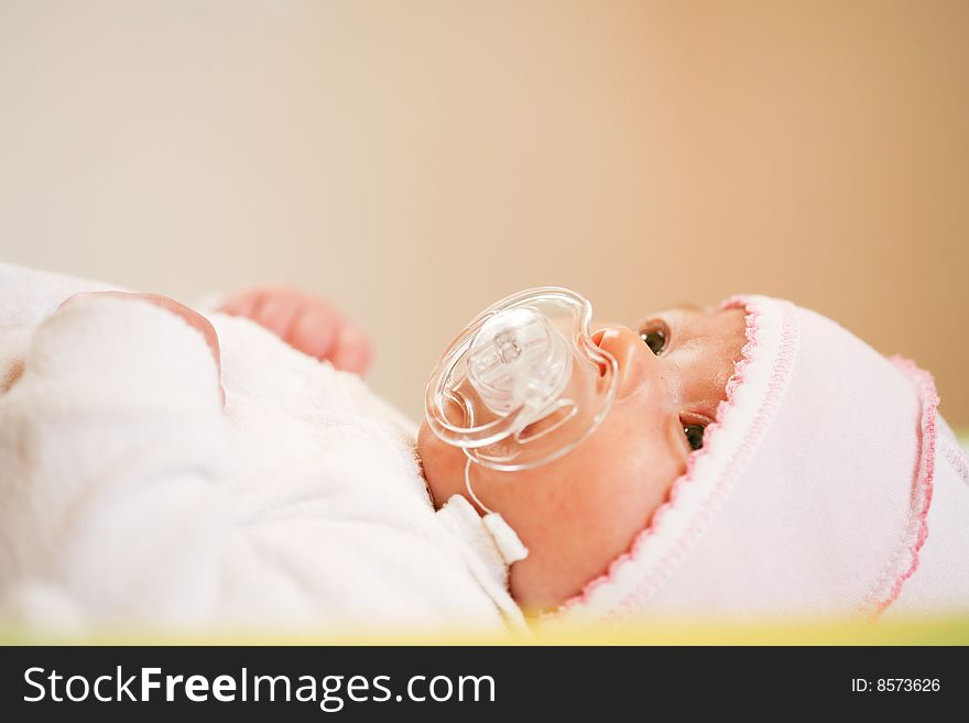 Adorable baby with pacifier on a bad