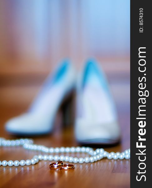 Beautiful wedding background with shoes, beads and gold rings (shallow DOF)