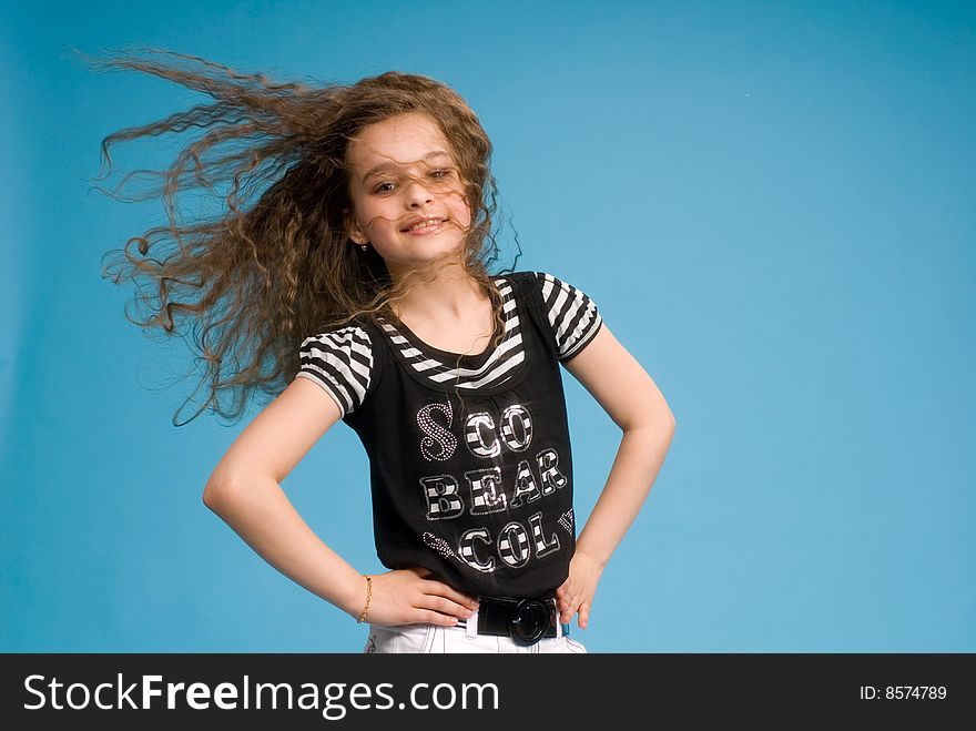 Young sweet girl showing her healthy beautiful long brown curly hair in motion created by wind. Young sweet girl showing her healthy beautiful long brown curly hair in motion created by wind