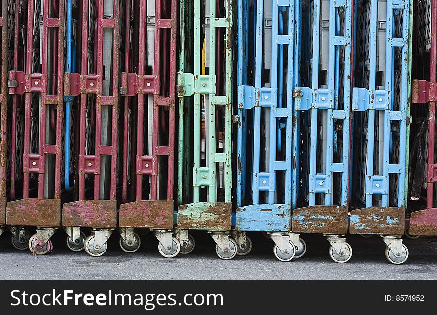 A line of old trolleys. They are weathered but they still have attractive colours. Could be used for transferring or transporting stuff.