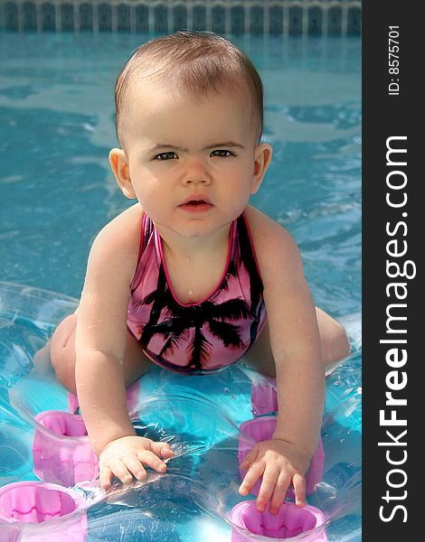 Baby sitting on an inflateble raft, floating in the water. Baby sitting on an inflateble raft, floating in the water