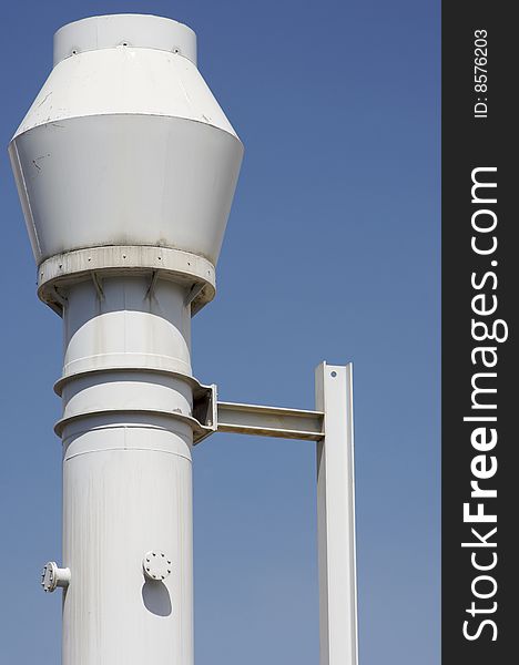 Industrial metal chimney white against a blue sky in Spain. Industrial metal chimney white against a blue sky in Spain