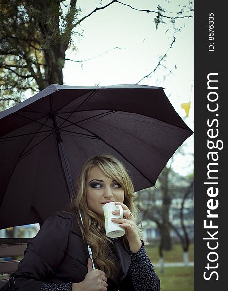 Girl with umbrella drink tea at autumn park. Girl with umbrella drink tea at autumn park.