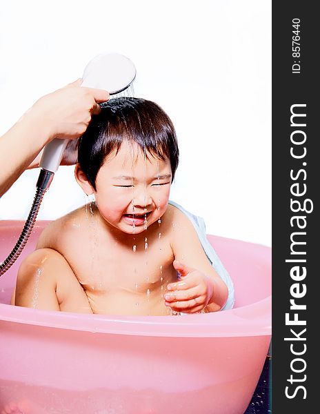 A picture of a little chinese boy taking bath and playing with water happily. A picture of a little chinese boy taking bath and playing with water happily