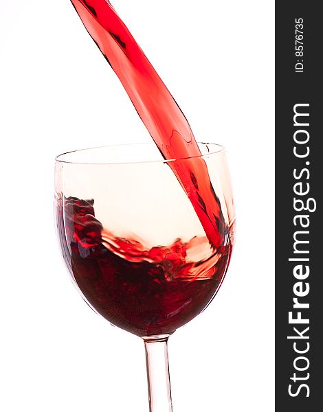Pour the wine into a transparent glass on a white background. Pour the wine into a transparent glass on a white background