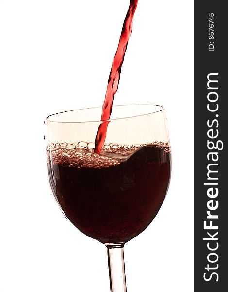 Pour the wine into a transparent glass on a white background. Pour the wine into a transparent glass on a white background