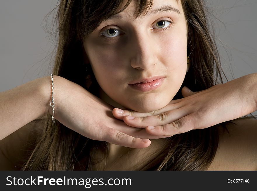 Smiling teenager with the hand near the face portrait