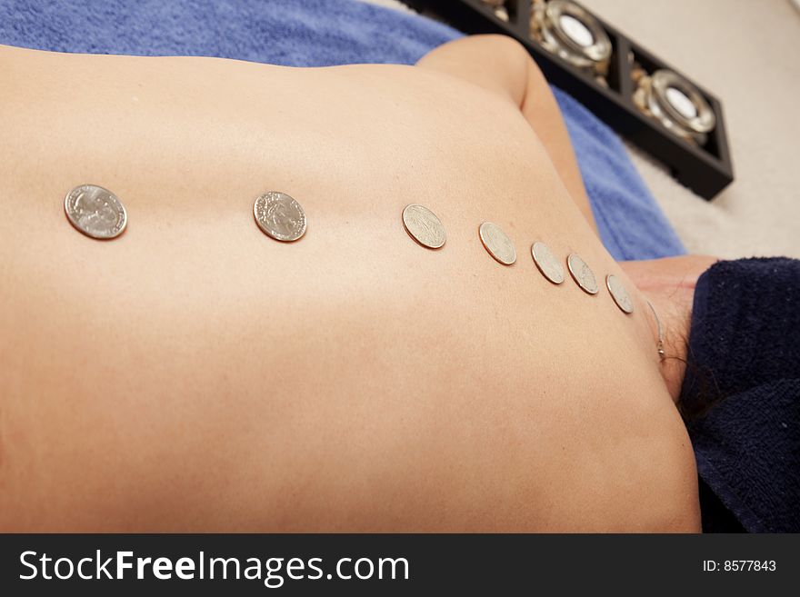 A play on hotstone massage therapy, with coins lined down a womans back. Financial worry therapy with quarters. A play on hotstone massage therapy, with coins lined down a womans back. Financial worry therapy with quarters.