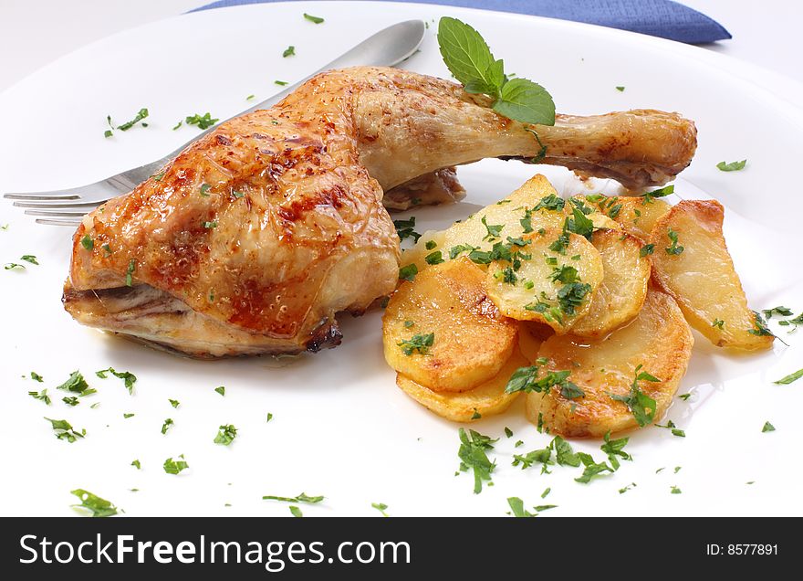 Grilled chicken leg with potato and parsley