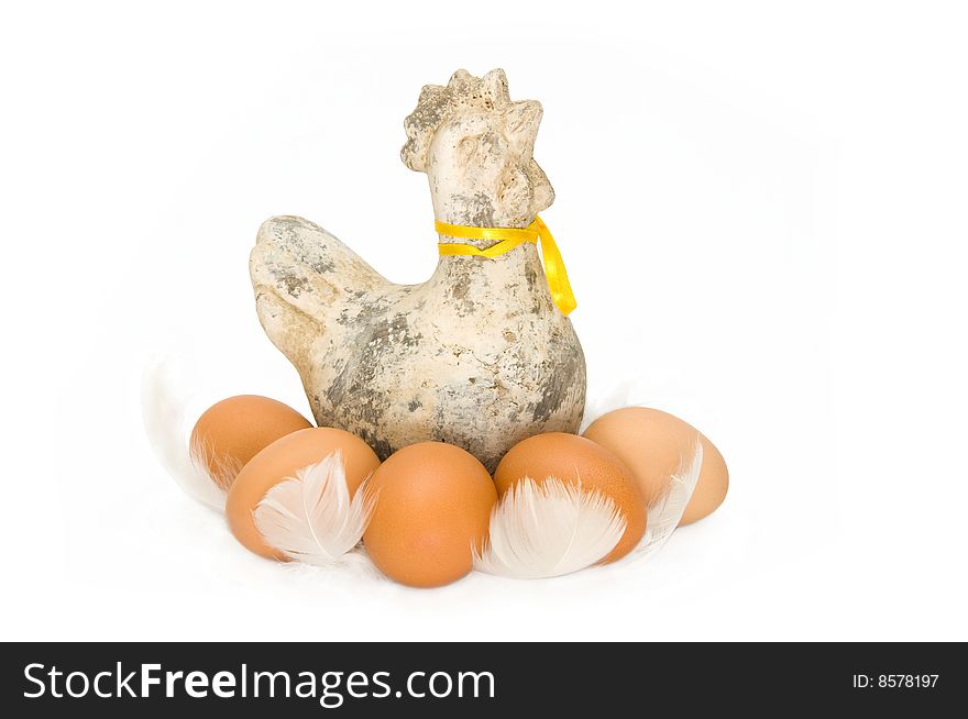 An ceramic chicken with real brown eggs between white feathers. An ceramic chicken with real brown eggs between white feathers