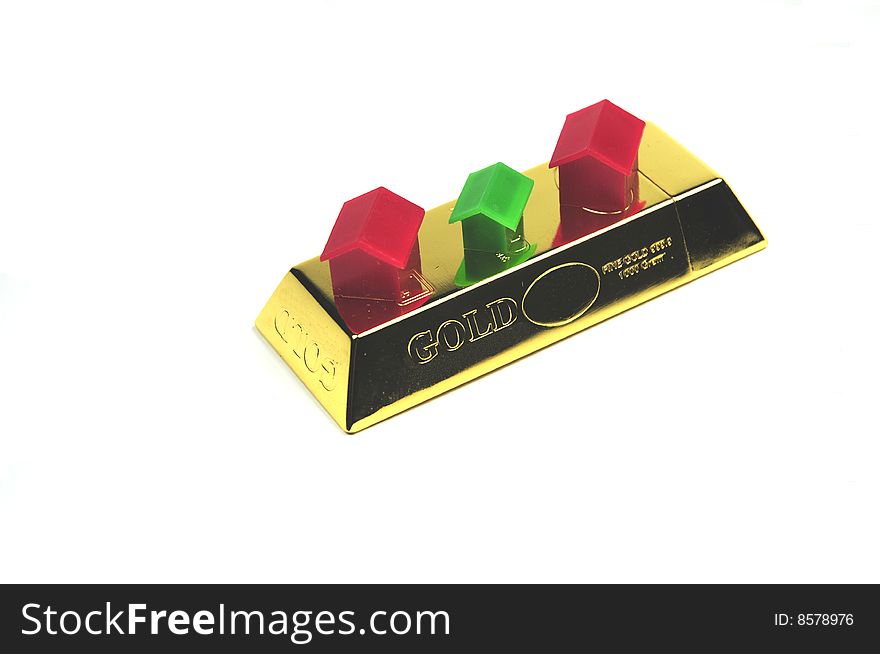Some miniature houses placed on a bar of gold. Some miniature houses placed on a bar of gold