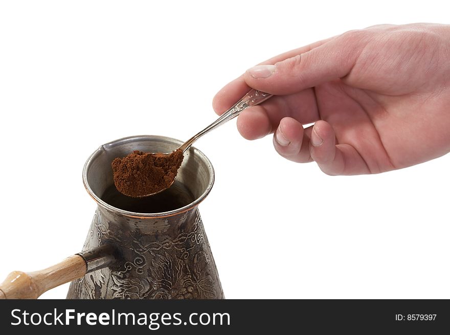 The spoon of ground coffee fallen asleep in a coffee maker on white background