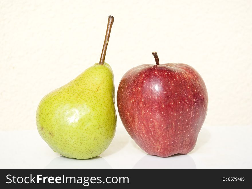 Reds apple and green pear on white background. Reds apple and green pear on white background