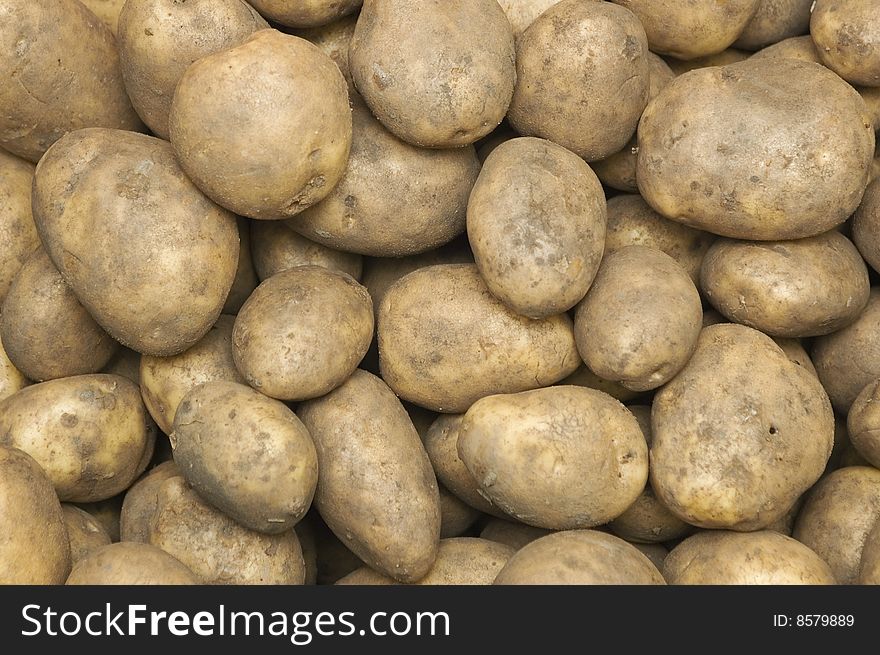 Plenty of fresh, raw potatoes on sale at a vegetable/farmer's market. Plenty of fresh, raw potatoes on sale at a vegetable/farmer's market.