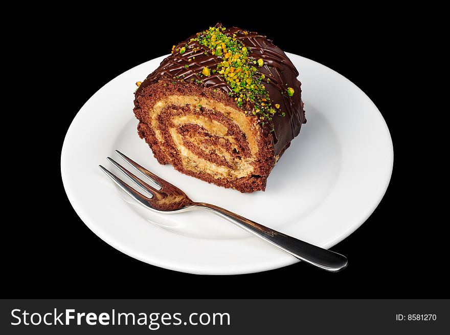 Piece of chocolate and nut roll on plate, isolated on black