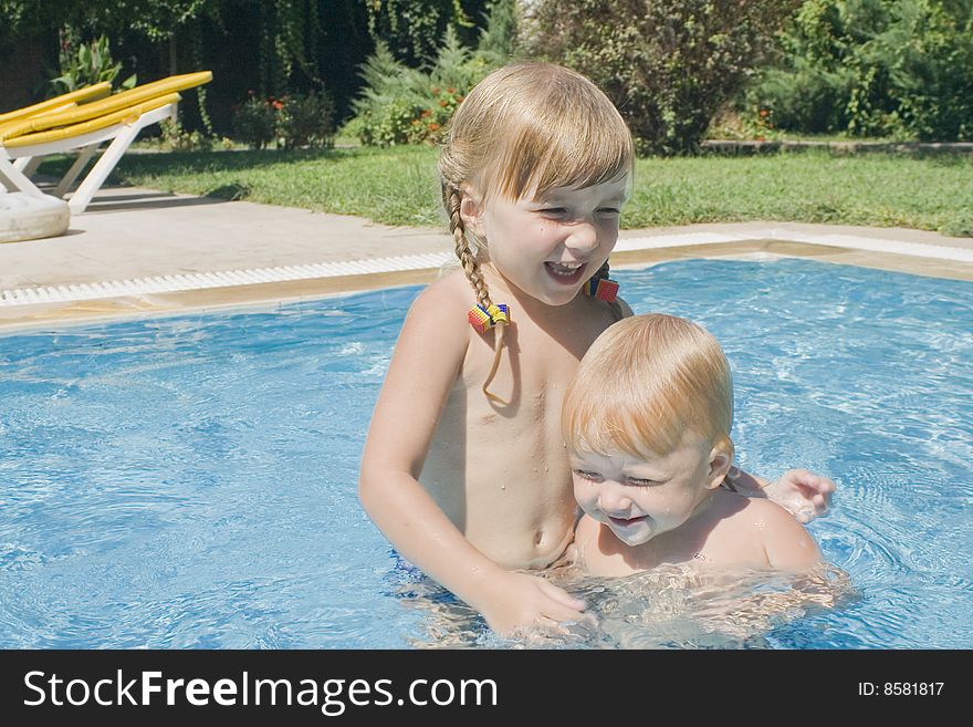 Two pretty little girls have a fun in children`s swimming-pool. Two pretty little girls have a fun in children`s swimming-pool