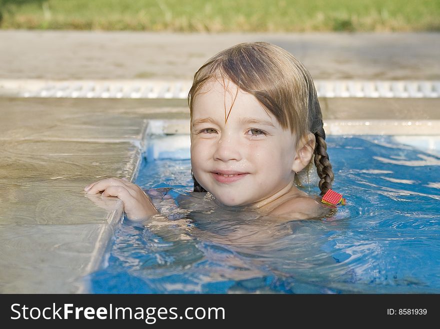 Pretty and cheerful little girl  have a fun and swim in the swimming-pool. Pretty and cheerful little girl  have a fun and swim in the swimming-pool