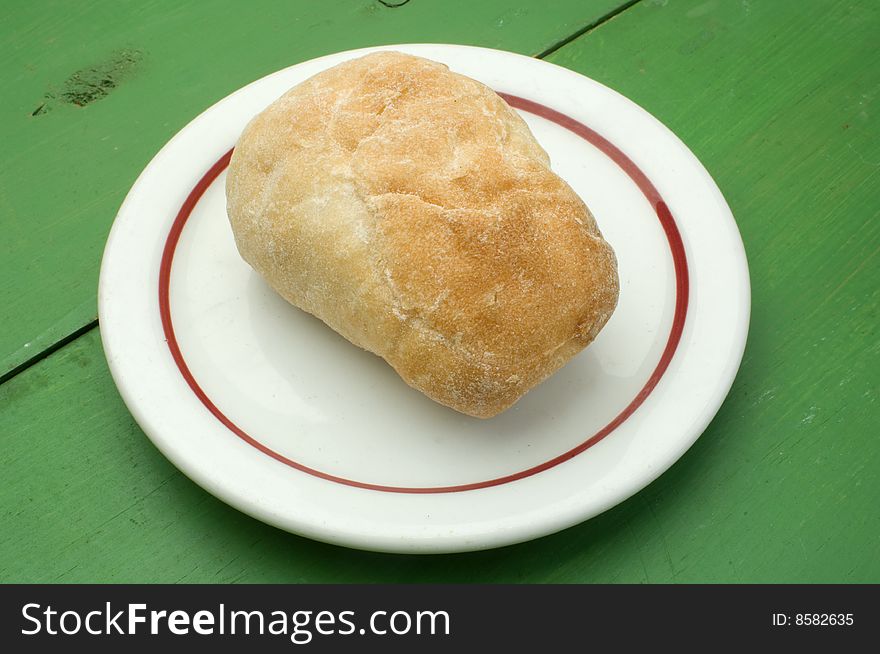 A dinner roll on a white plate