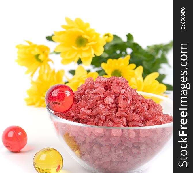 Spa products: bath salt, oil balls in a bowl and yellow flowers