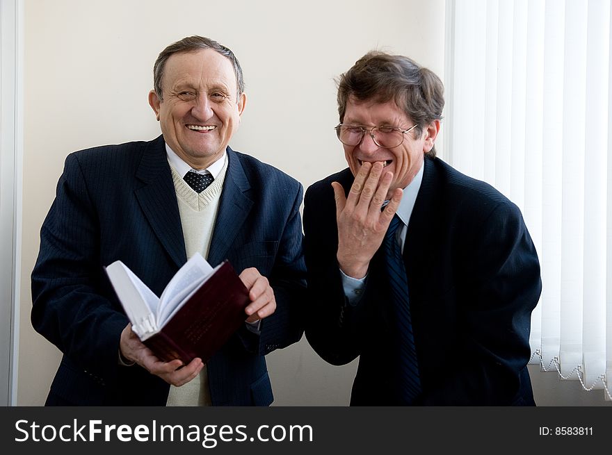 Portrait of a two senior businessmen reading the book