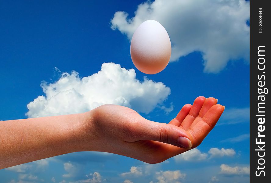 Women hand with egg on sky background with clipping path