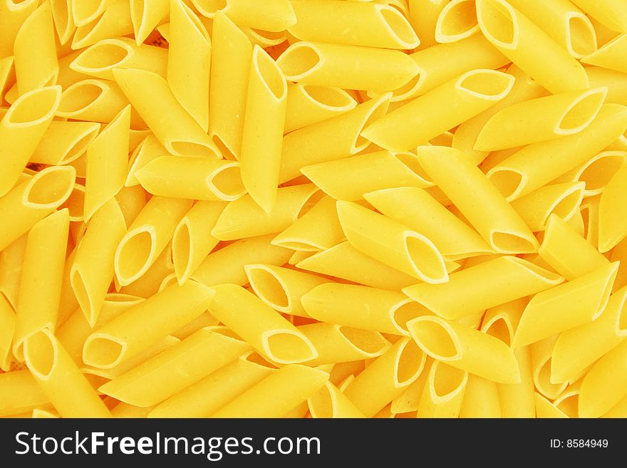 Background of yellow uncooked pasta. Background of yellow uncooked pasta.