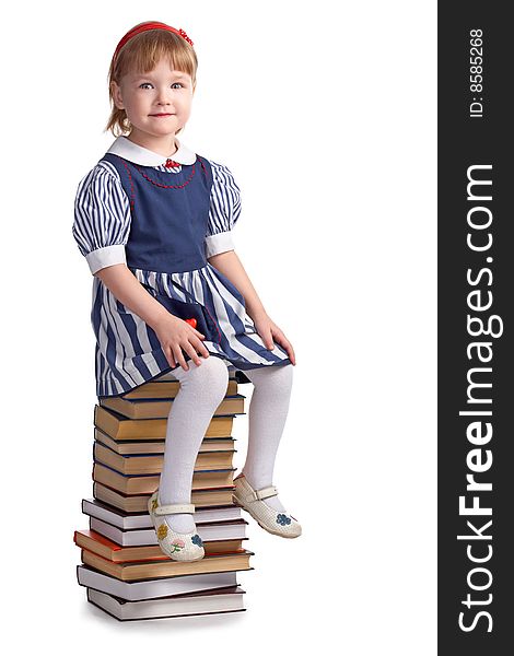 Schoolgirl sitting on the heap of books  on white background