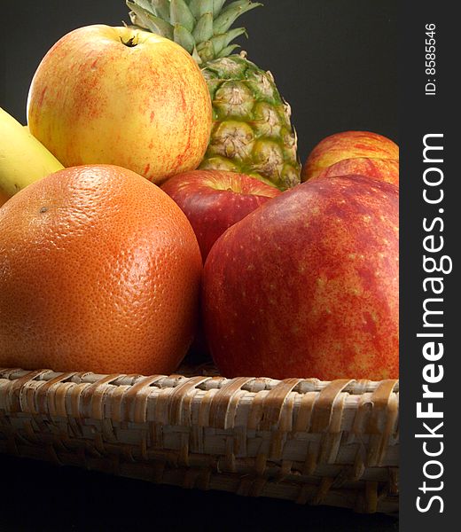 Fresh fruit in a basket on a black background. Fresh fruit in a basket on a black background.