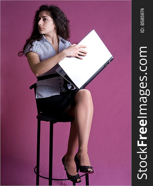 Portrait of young attractive woman sitting full-length on high chair holding a folder with documents, looking aside and away. Portrait of young attractive woman sitting full-length on high chair holding a folder with documents, looking aside and away.