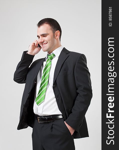 Portrait of a young smiling business man using cell phone. Portrait of a young smiling business man using cell phone