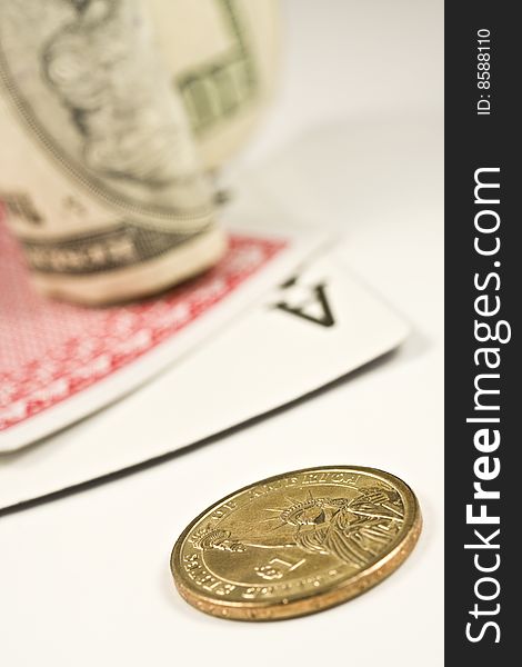 Dollar bill and coin with pair of cards isolated on a white background