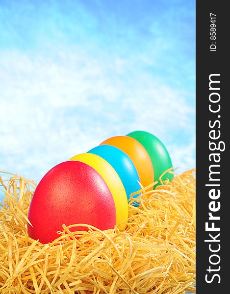 Five Painted Eggs In Straw On A Sky Background