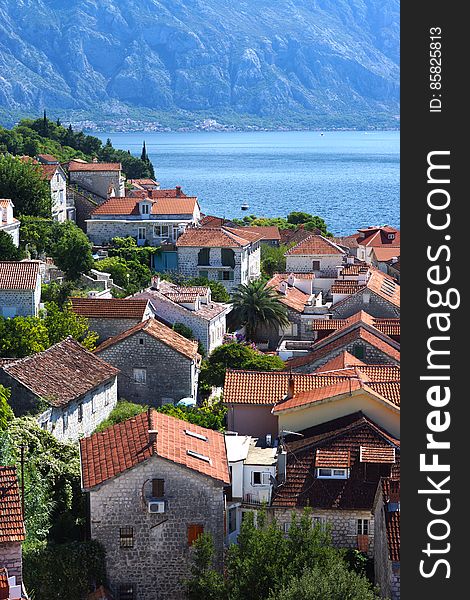 Top view of red tiled roofs and courtyards in a small town in Montenegro, tourists